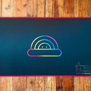Red Playmat on Table with Chasing Rainbows Logo and Inclusive Imagination Logo in Rainbow Gradient