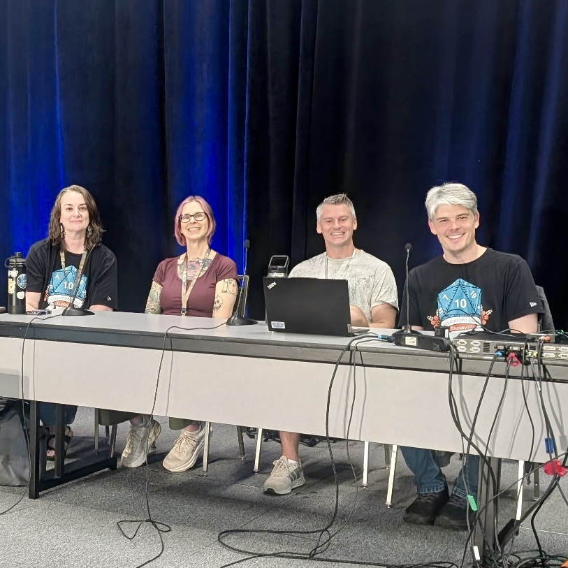 Garrett and 3 cohort members sitting at a table leading a panel at the PAX West gaming convention.